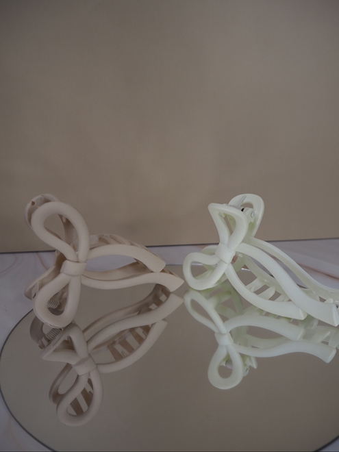 italienische mode kleiber werksverkauf Zwei pastellfarbene Haarspangen in Schleifenform, eine beige, eine weiß
