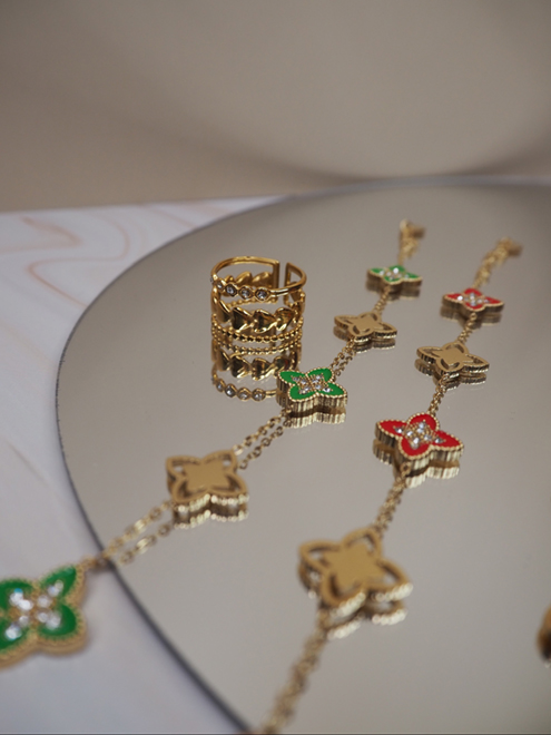 italienische mode kleiber werksverkauf Goldene Halskette und Ring mit emaillierten Blumenakzenten und klaren Steinen.