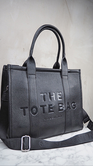italienische mode kleiber werksverkauf Schwarze Einkaufstasche aus Leder mit der Prägung „THE TOTE BAG“.