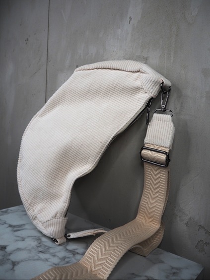 italienische mode kleiber werksverkauf Cremefarbene Umhängetasche aus Cord mit gemustertem Riemen, ein modisches Accessoire.