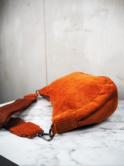 italienische mode kleiber werksverkauf Orangefarbene Cord-Umhängetasche auf Marmoroberfläche, Herbstmode-Accessoire