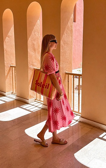 italienische mode kleiber werksverkauf Frau mit Sonnenkleid und "Soleil"-Tasche im Schatten