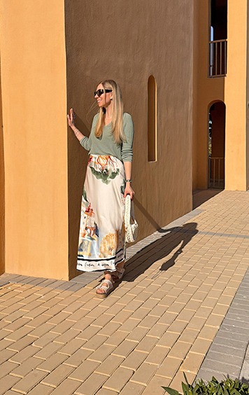 italienische mode kleiber werksverkauf Frau in langem Rock und Pullover lehnt an Wand