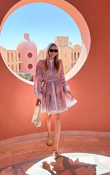 italienische mode kleiber werksverkauf Frau im Sommerkleid vor pastellfarbener Architektur