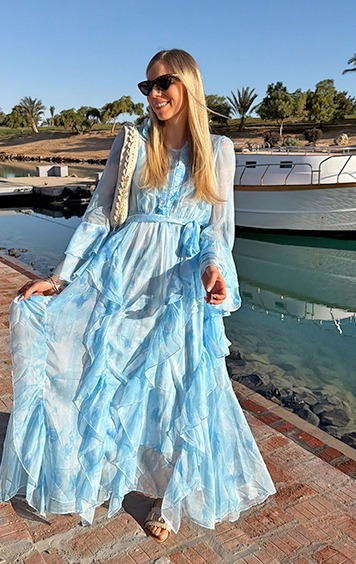 italienische mode kleiber werksverkauf Frau in blauem Maxikleid am Wasser