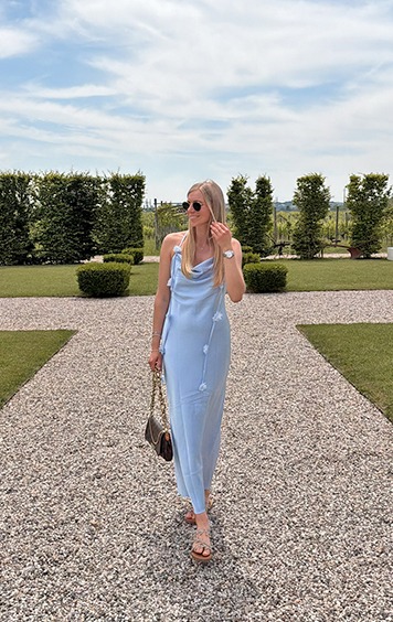 italienische mode kleiber werksverkauf Frau in hellblauem Kleid mit Blumenapplikationen im Freien