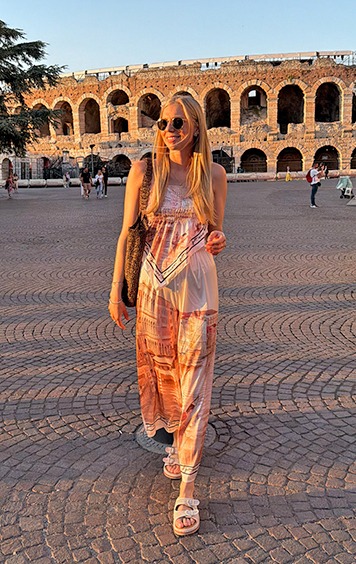 italienische mode kleiber werksverkauf Frau in langem Kleid vor römischem Amphitheater in Verona