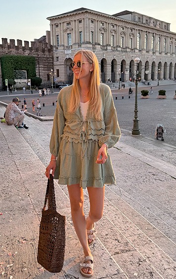 italienische mode kleiber werksverkauf Junge Frau in Sommerkleidung geht die Treppen hinauf vor historischer Architektur