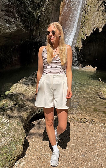 italienische mode kleiber werksverkauf Frau in Shorts und Top steht vor einem Wasserfall