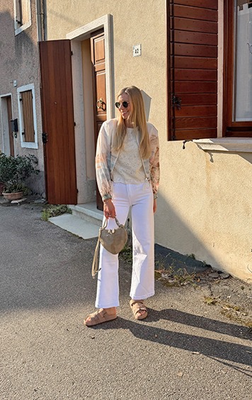 italienische mode kleiber werksverkauf Frau mit weißer Hose und Blumenbluse in Italien