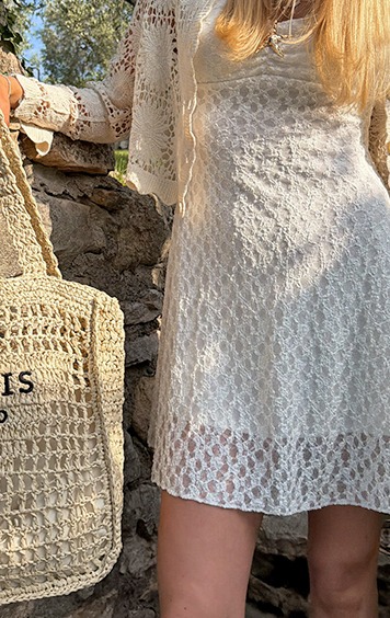 italienische mode kleiber werksverkauf Frau im cremefarbenen Häkelkleid mit passender Tasche