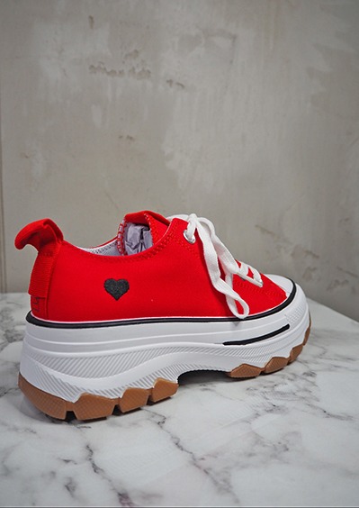 italienische mode kleiber werksverkauf Roter Sneaker mit Herz-Logo auf Marmoruntergrund