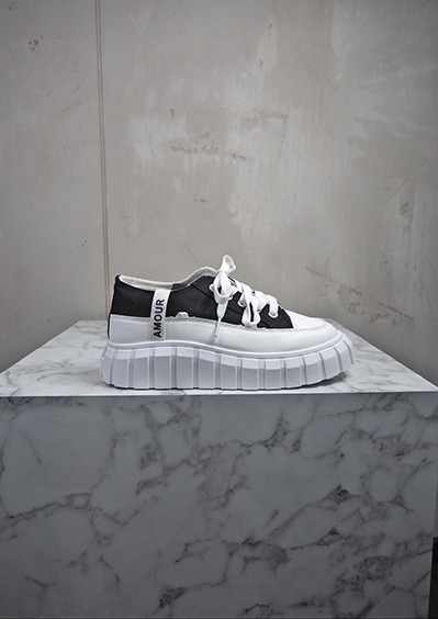 italienische mode kleiber werksverkauf Schwarzer und weißer Sneaker mit dicker Sohle und dem Aufdruck "AMOUR
