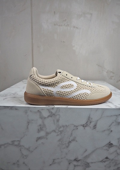 italienische mode kleiber werksverkauf Beige Sneaker mit weißem Gittermuster auf Marmorsockel
