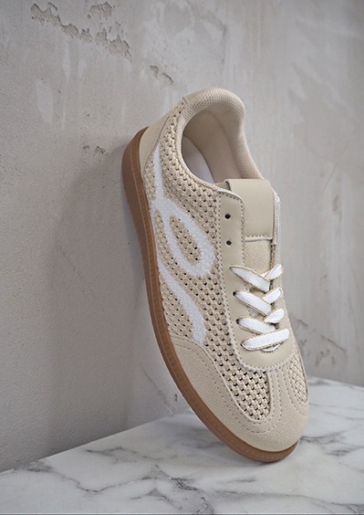 italienische mode kleiber werksverkauf Beiger Sneaker mit weißem Design auf Marmorplatte