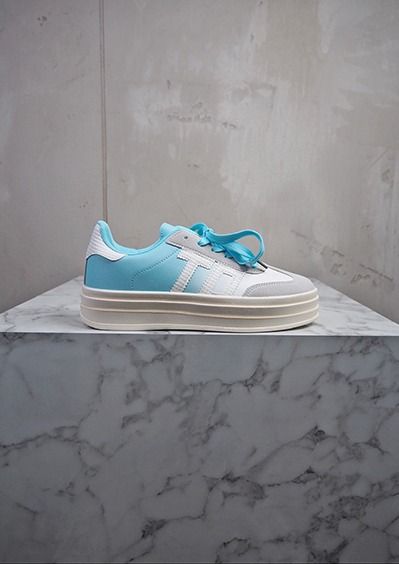 italienische mode kleiber werksverkauf Hellblauer und weißer Sneaker mit dicker Sohle auf Marmorsockel