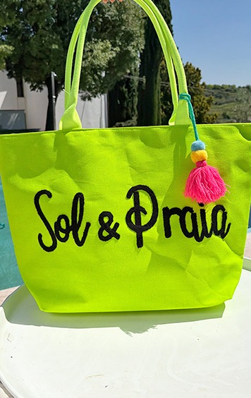italienische mode kleiber werksverkauf Neongrüne Strandtasche mit der Aufschrift "Sol & Praia" und einem bunten Bommel