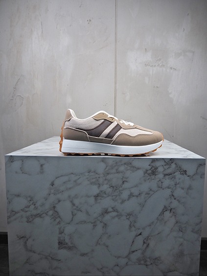 italienische mode kleiber werksverkauf Brauner Retro-Sneaker mit weißen Akzenten auf Marmorsockel