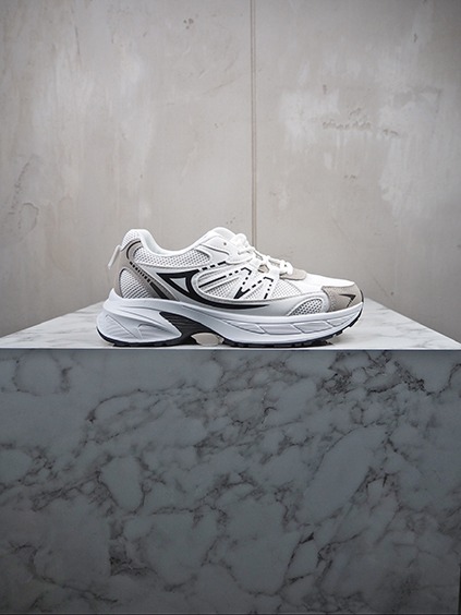 italienische mode kleiber werksverkauf Weißer Damen-Sneaker mit grauen Akzenten auf Marmorsockel