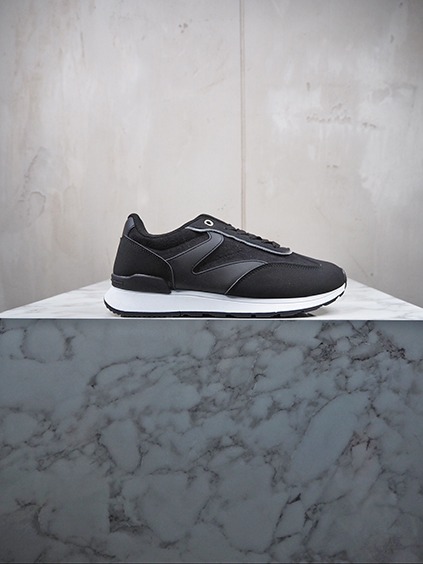 italienische mode kleiber werksverkauf Schwarzer Herren-Sneaker aus Leder und Mesh auf Marmorsockel