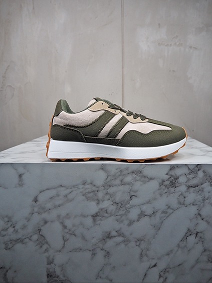 italienische mode kleiber werksverkauf Grüner Adidas Sneaker mit weißer Sohle auf Marmor