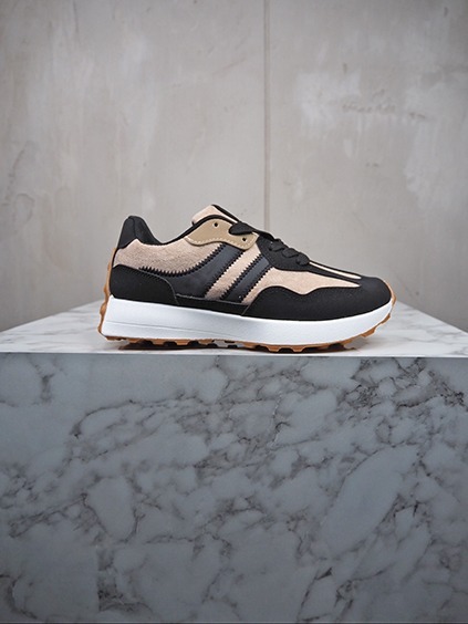 italienische mode kleiber werksverkauf Schwarzer Sneaker mit beigen und braunen Akzenten auf Marmor