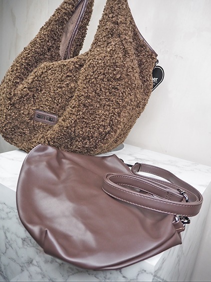italienische mode kleiber werksverkauf Zwei modische Damenhandtaschen: eine braune Teddy-Tasche und eine schlichte Leder-Tasche.