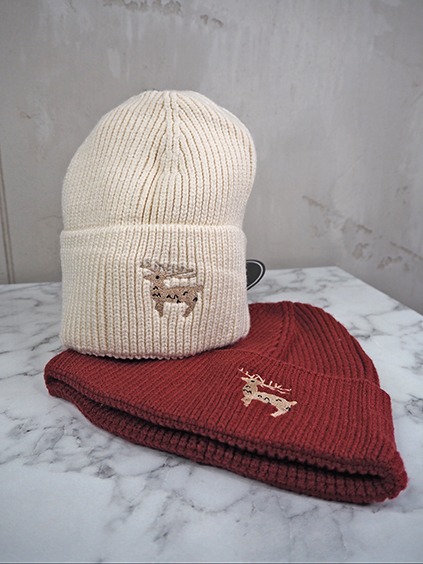 italienische mode kleiber werksverkauf Zwei Strickmützen mit Rentierstickerei, eine beige, eine rot.