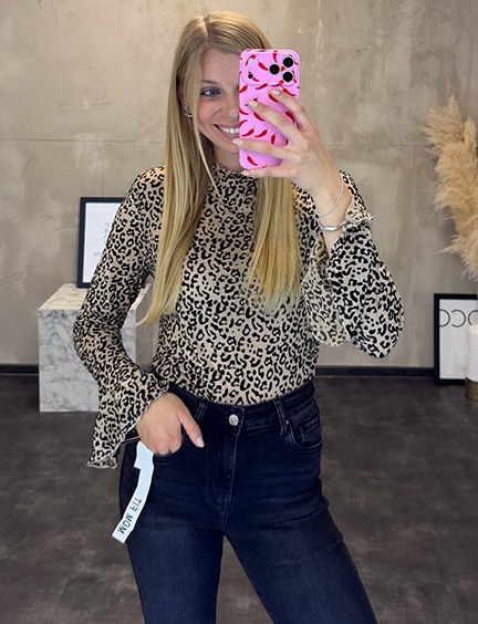 italienische mode kleiber werksverkauf Frau im Leo-Muster-Oberteil und Jeans, hält Smartphone