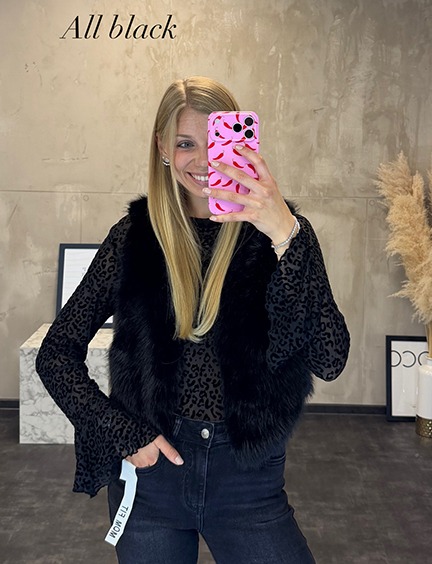 italienische mode kleiber werksverkauf Frau im stylischen All-Black-Outfit mit Fellweste und Leoparden-Top