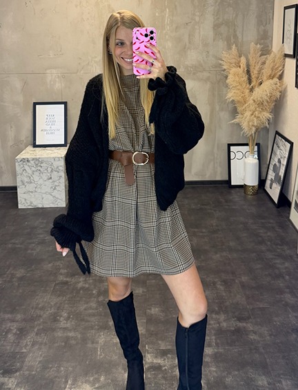 italienische mode kleiber werksverkauf Frau im karierten Kleid mit Strickjacke, braunem Gürtel und hohen Stiefeln