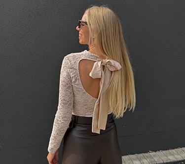 italienische mode kleiber werksverkauf Frau in modischem Outfit mit Spitze und Schleife, aktuelle italienische Mode